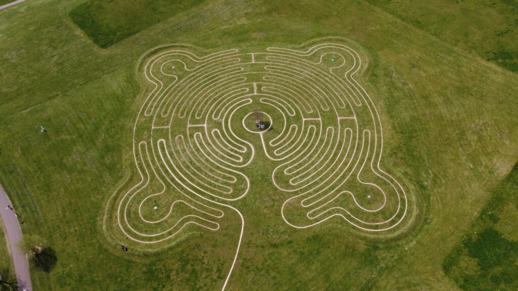 Labyrinthe gravé dans un champ herbeux.