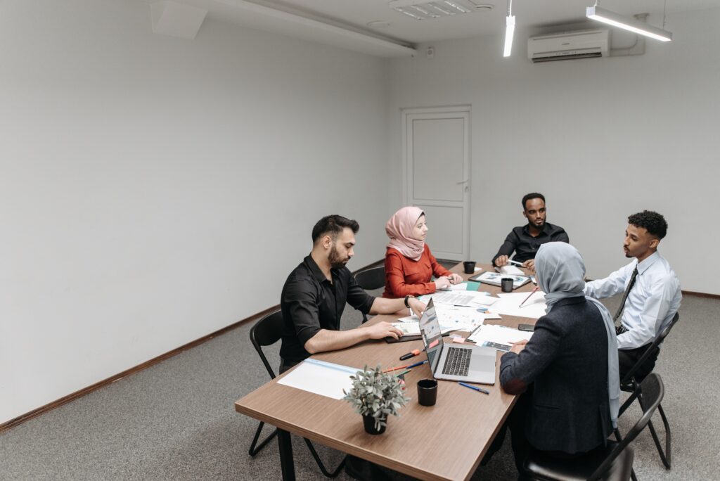 Group of people sitting around table for meeting.